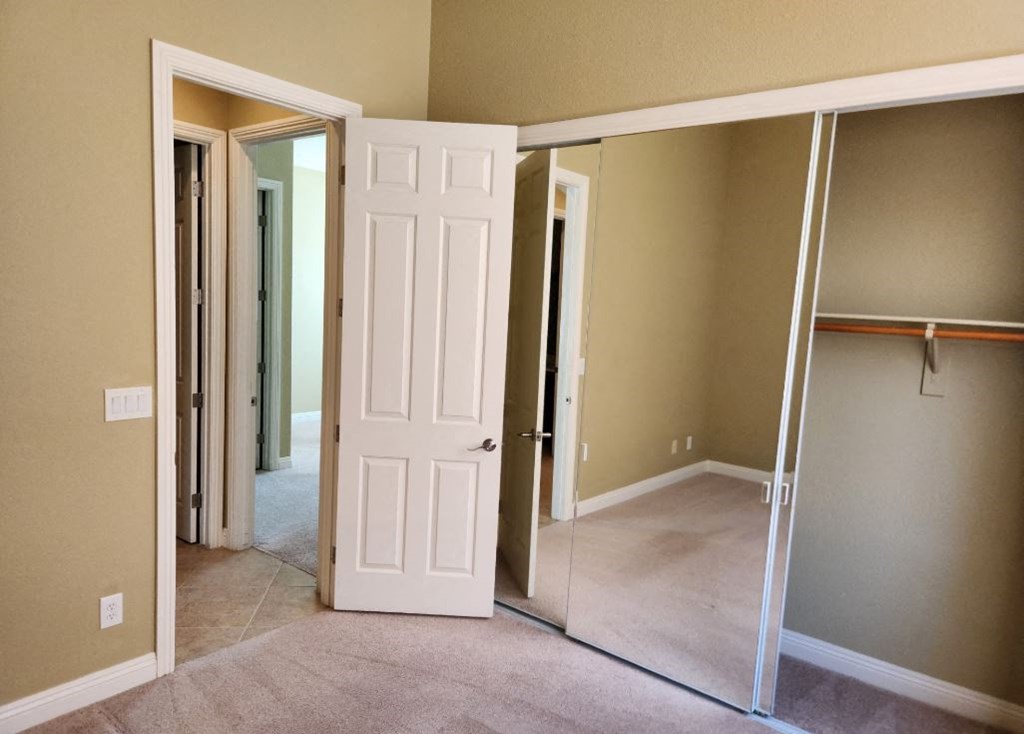 an empty room with a closet and a white door