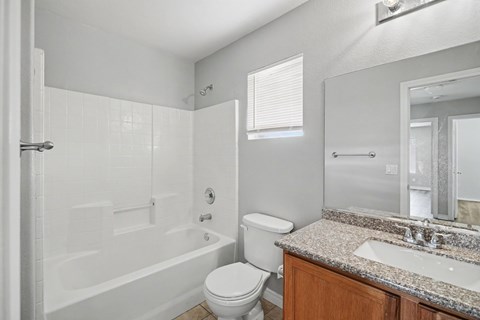 A white bathroom with a toilet, sink, and bathtub.