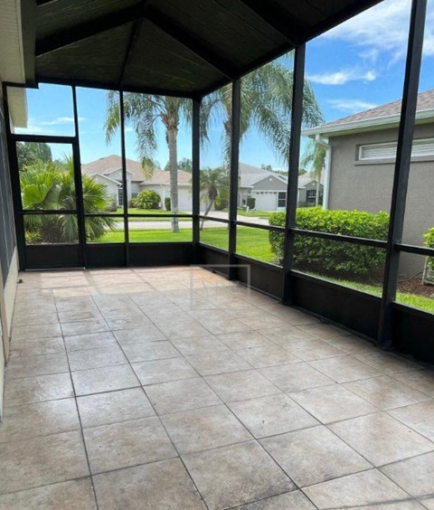 a screened in porch with a view of the grass