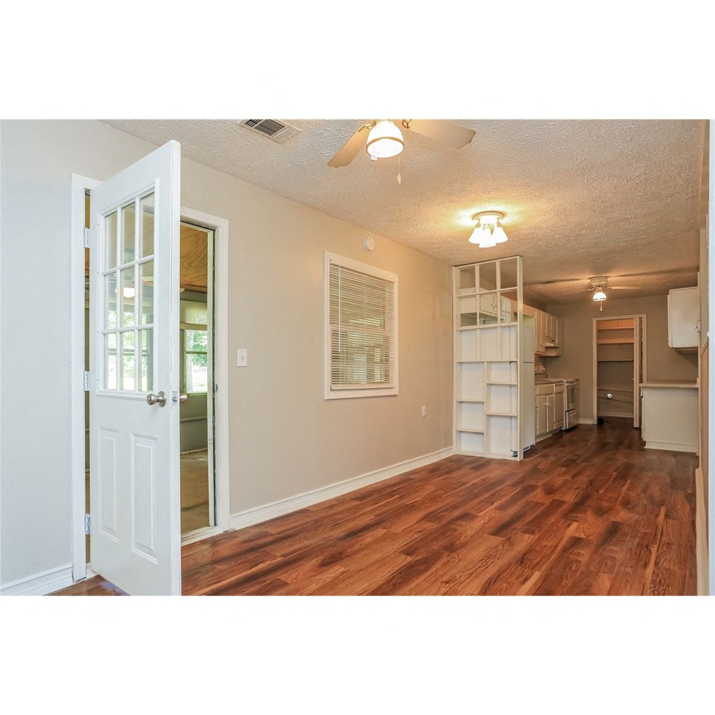 an open living room with a white door and a kitchen