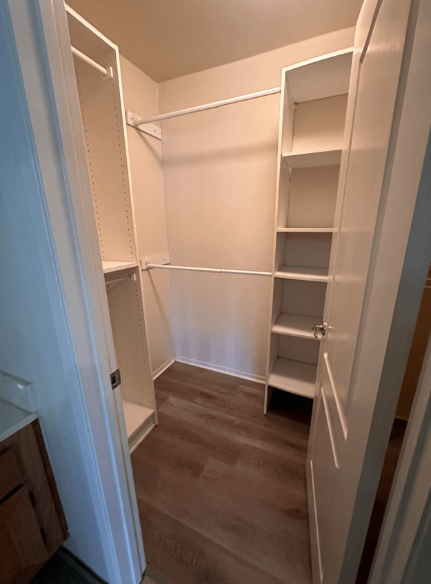 a walk in closet with shelves and