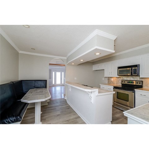 a white kitchen with a black couch and a table
