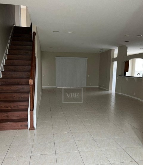 a living room with a staircase and a tile floor