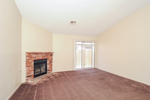 A room with a fireplace and carpeting.