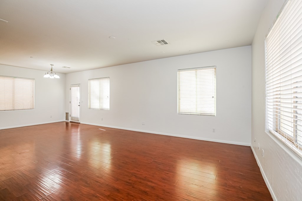 A large empty room with wooden floors and white walls.