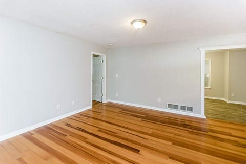 A room with wooden flooring and a white door.