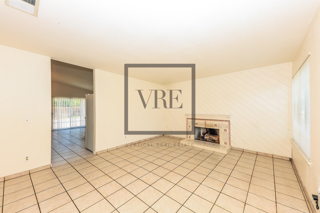 A large empty room with a fireplace and a VRE sign on the wall.