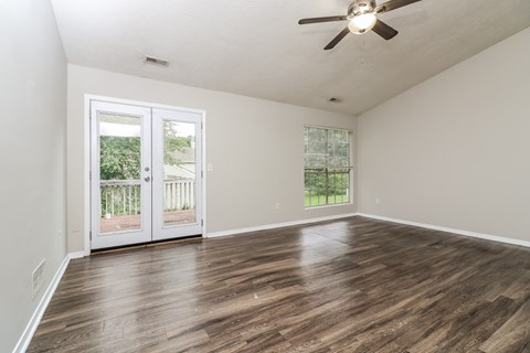 A room with a ceiling fan and a door leading outside.
