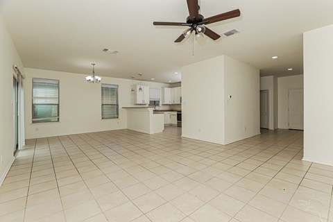 Empty room with a ceiling fan and tiled floor.