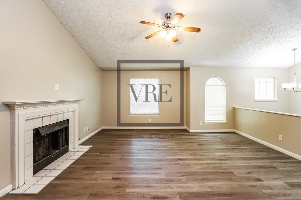 A spacious room with a fireplace and a large window.