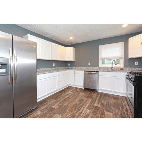 a kitchen with stainless steel appliances and white cabinets