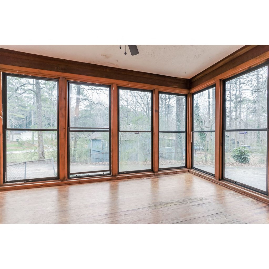 a living room with large windows and wood floors