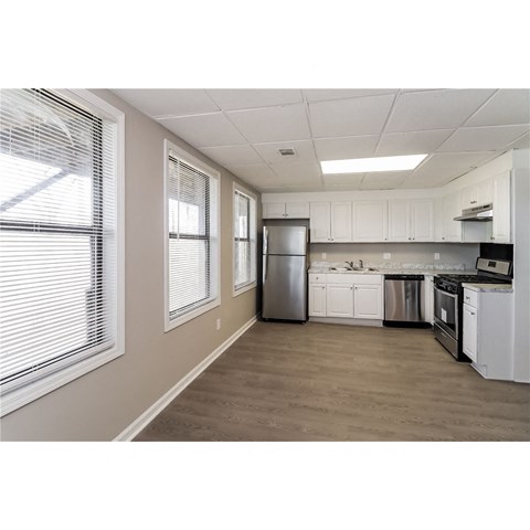 a kitchen with white cabinets and a stainless steel refrigerator