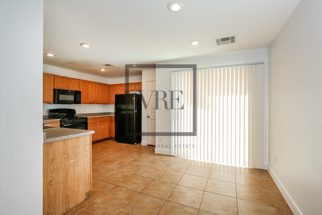 A kitchen with a refrigerator and microwave in it.