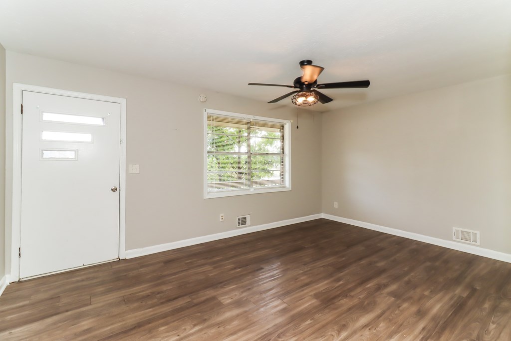 A room with a ceiling fan and a window.