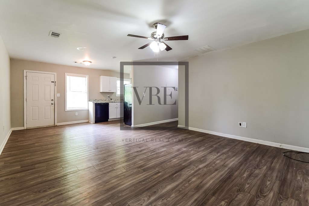 A room with wooden floors and a ceiling fan.