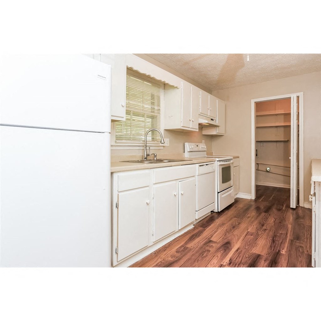 a kitchen with white cabinets and a sink and a refrigerator