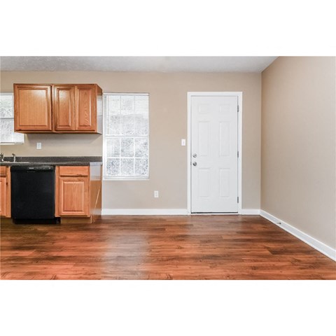 a kitchen with wooden cabinets and a white door