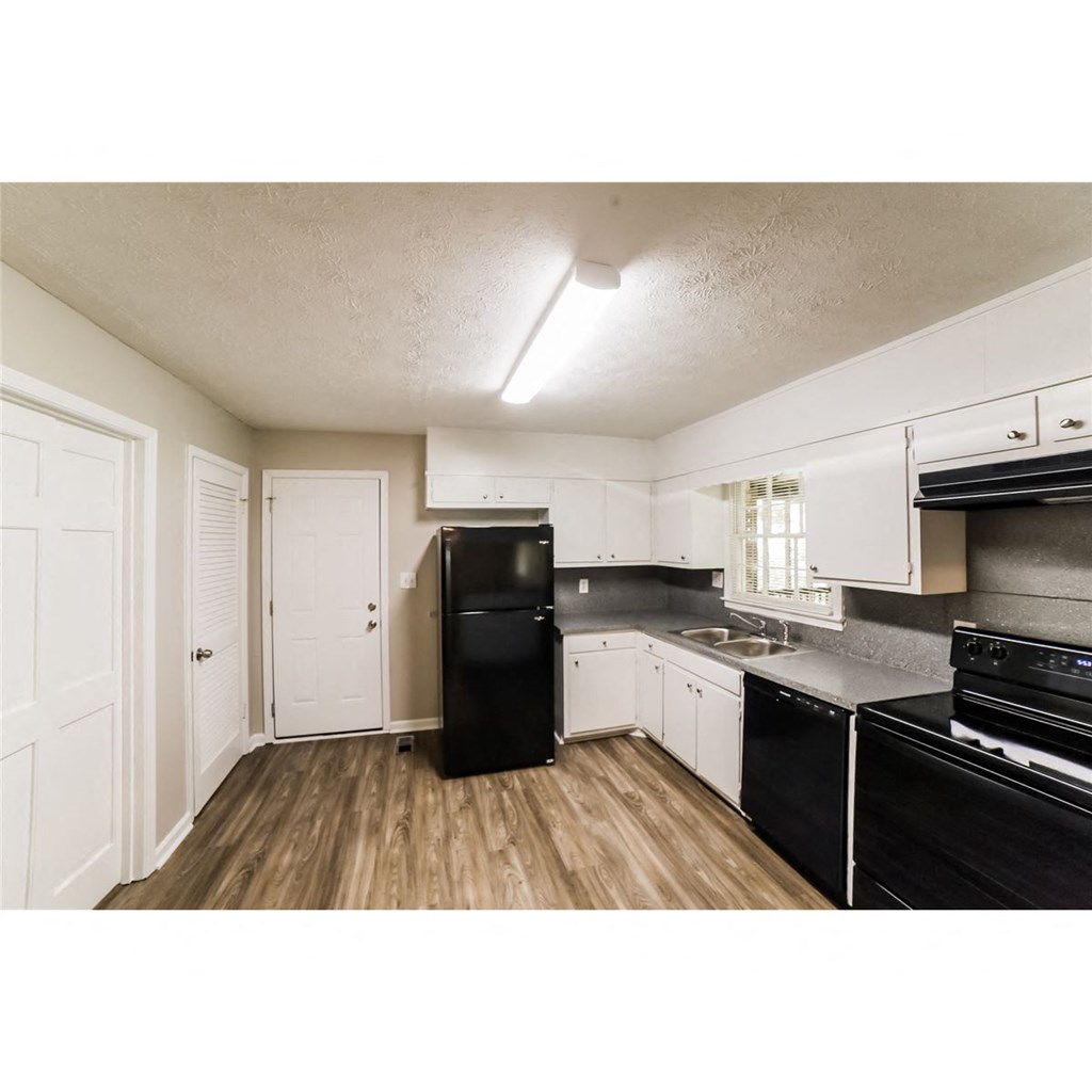 a kitchen with black appliances and white cabinets
