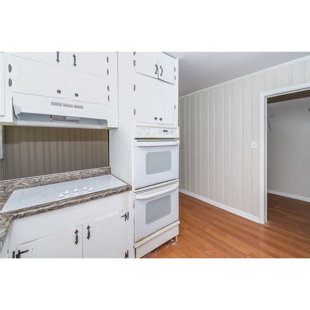 a kitchen with white cabinets and a stove top oven