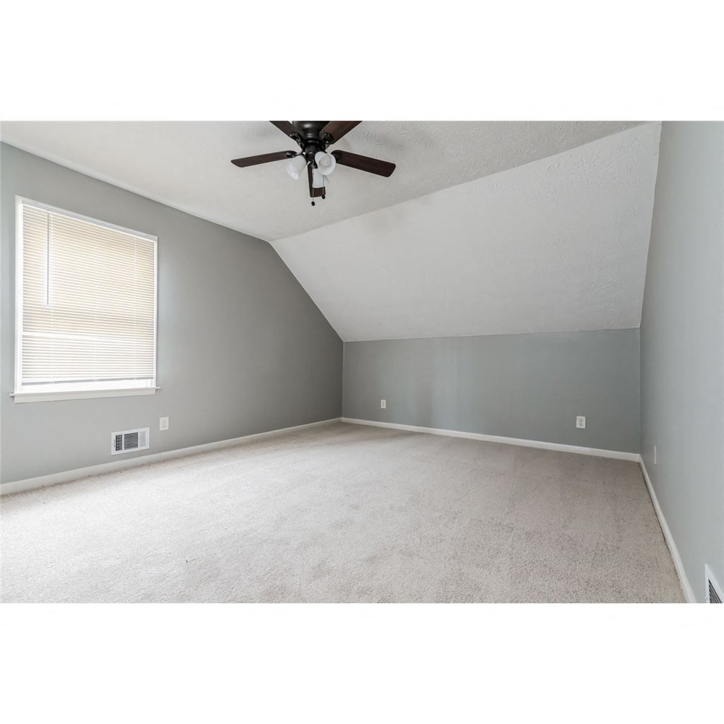 an empty bedroom with a ceiling fan