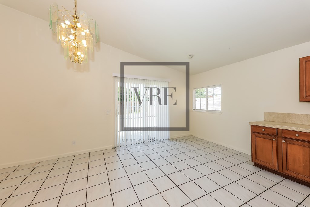 A large empty room with a chandelier and a sign that says "VERTIGUE".