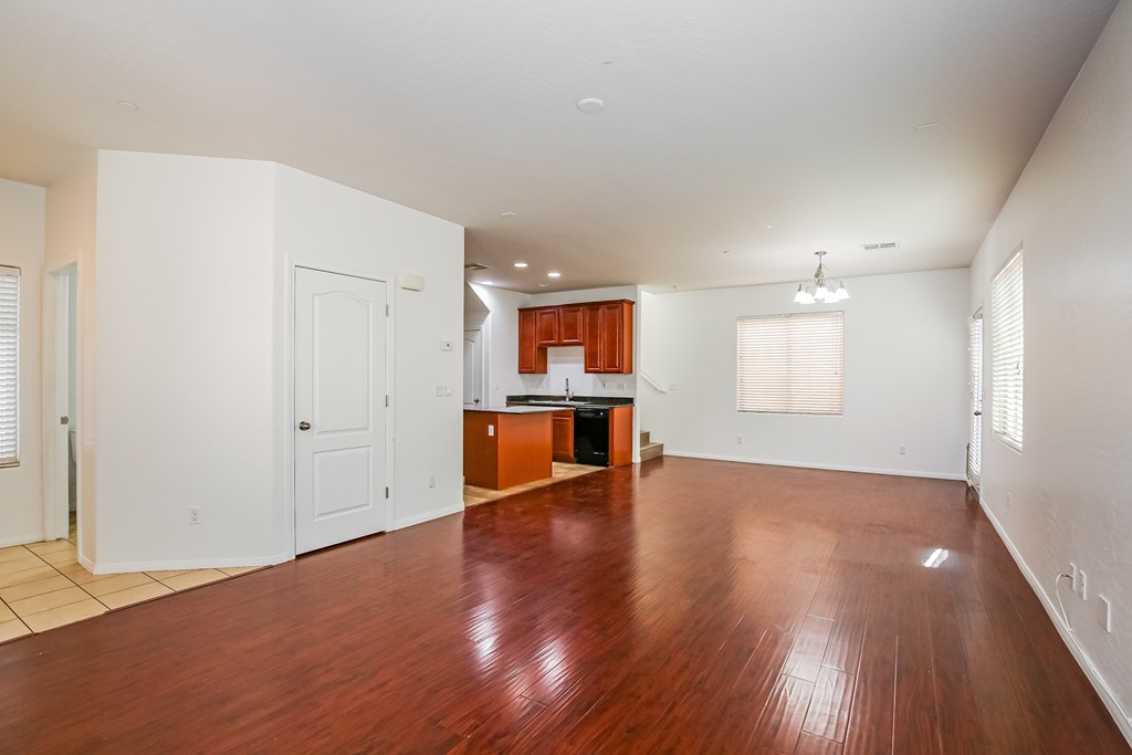 A large empty room with wooden floors and white walls.