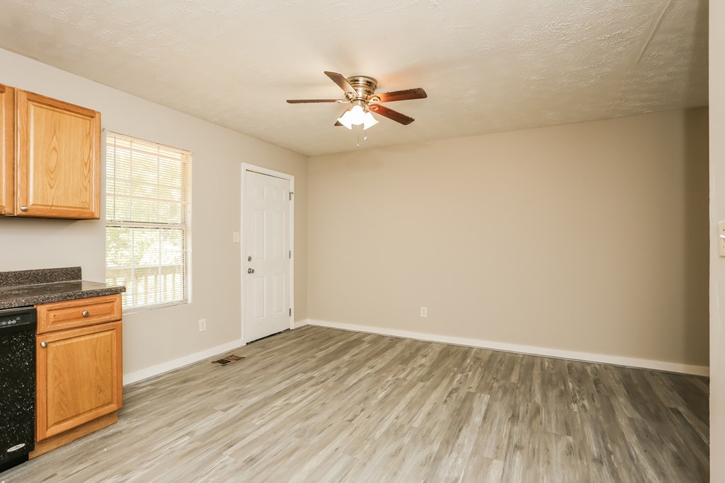 A kitchen with wooden cabinets and a black countertop.