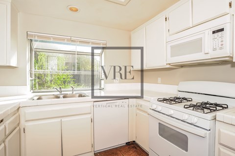 A kitchen with a white stove and cabinets with a VRE sign.