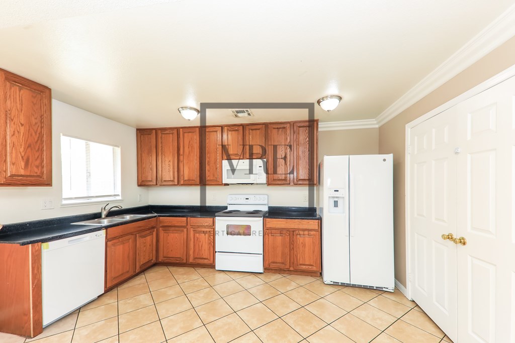A kitchen with wooden cabinets and white appliances.