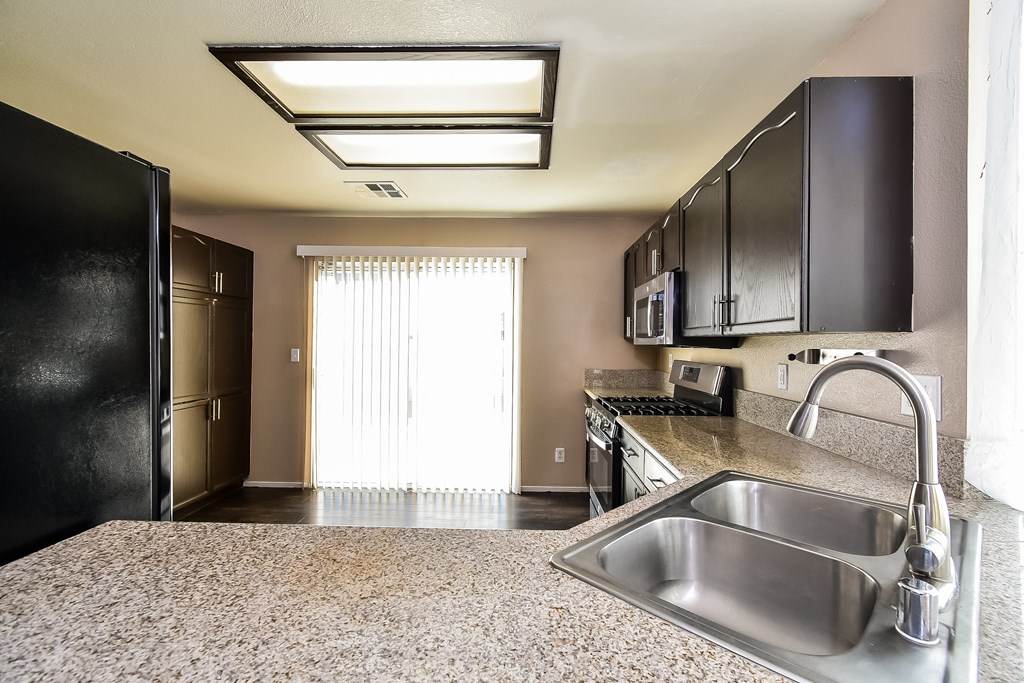 A kitchen with a sink and a refrigerator.
