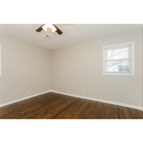 A room with a ceiling fan and a window.