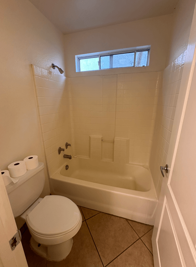 a small bathroom with a toilet and a bath tub