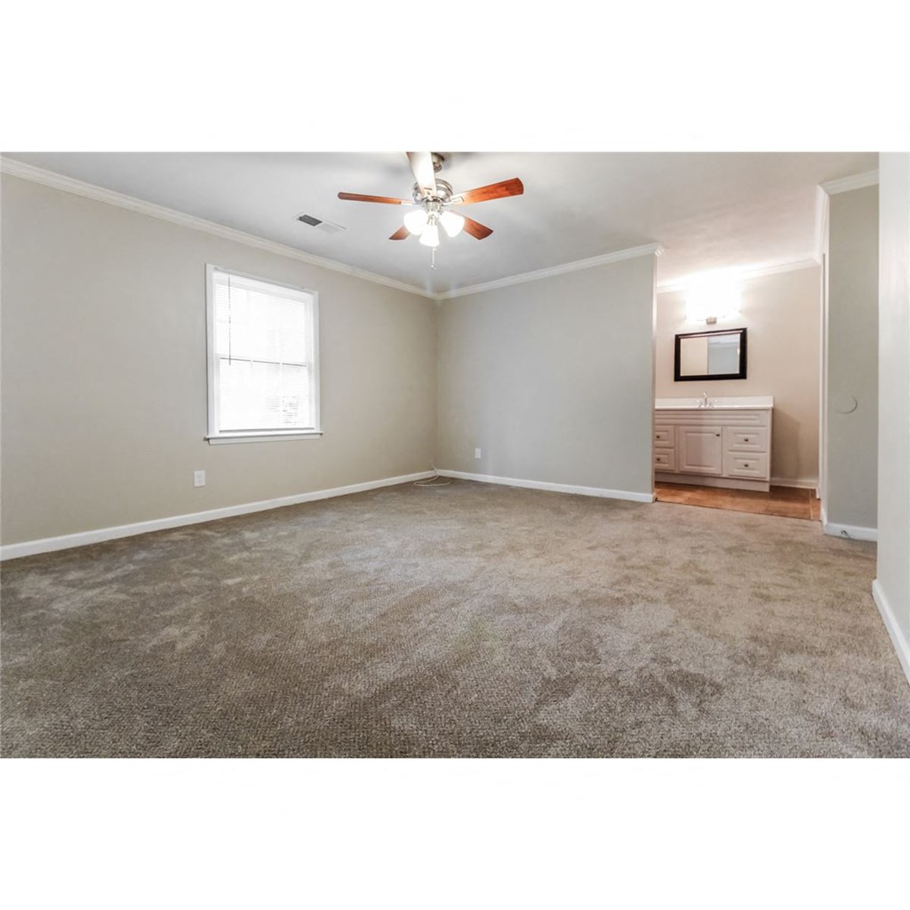 an empty living room with a ceiling fan