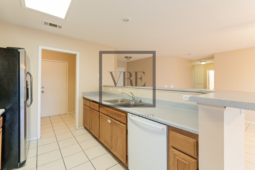 A kitchen with a fridge, dishwasher and a mirror.