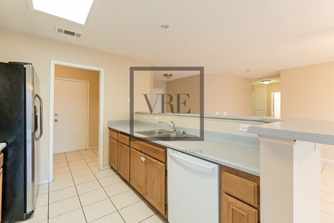 A kitchen with a fridge, dishwasher and a mirror.