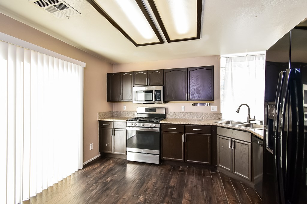 A kitchen with dark brown cabinets and stainless steel appliances.