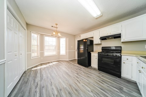 A kitchen with black appliances and white cabinets.