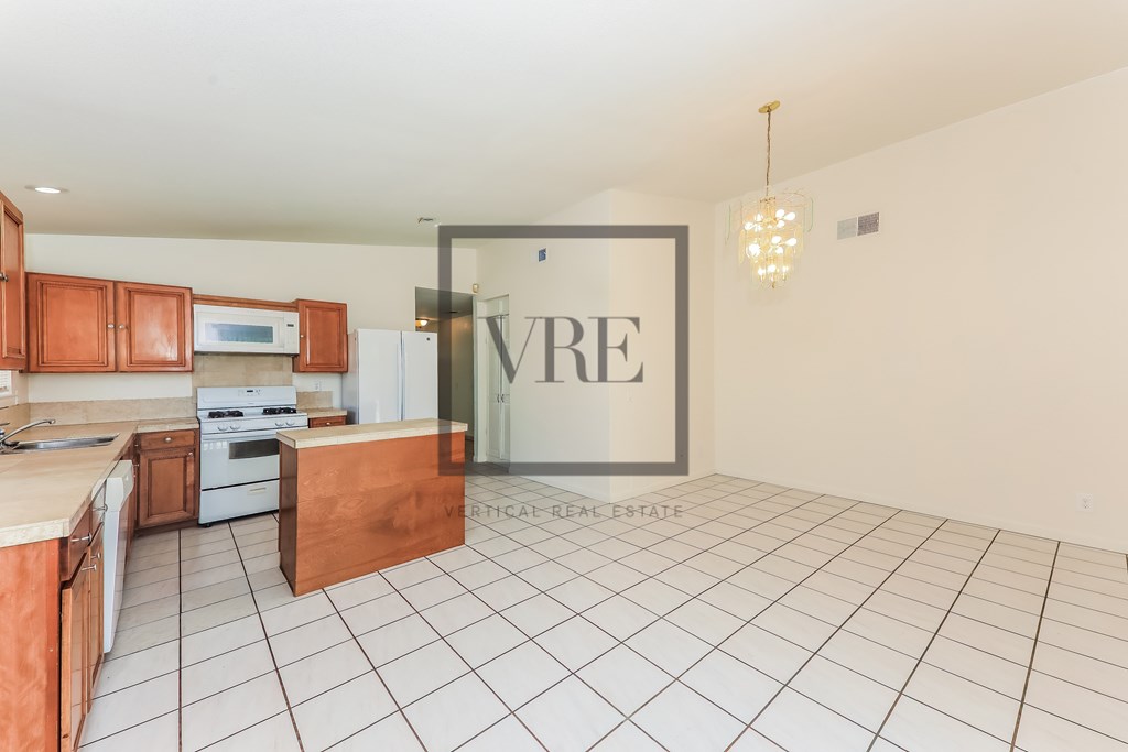 A kitchen with a white tile floor and a wooden island.