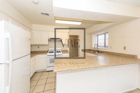 A kitchen with a white fridge and a counter top.