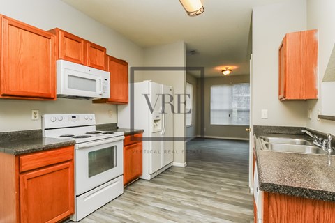 A kitchen with a white stove and orange cabinets.