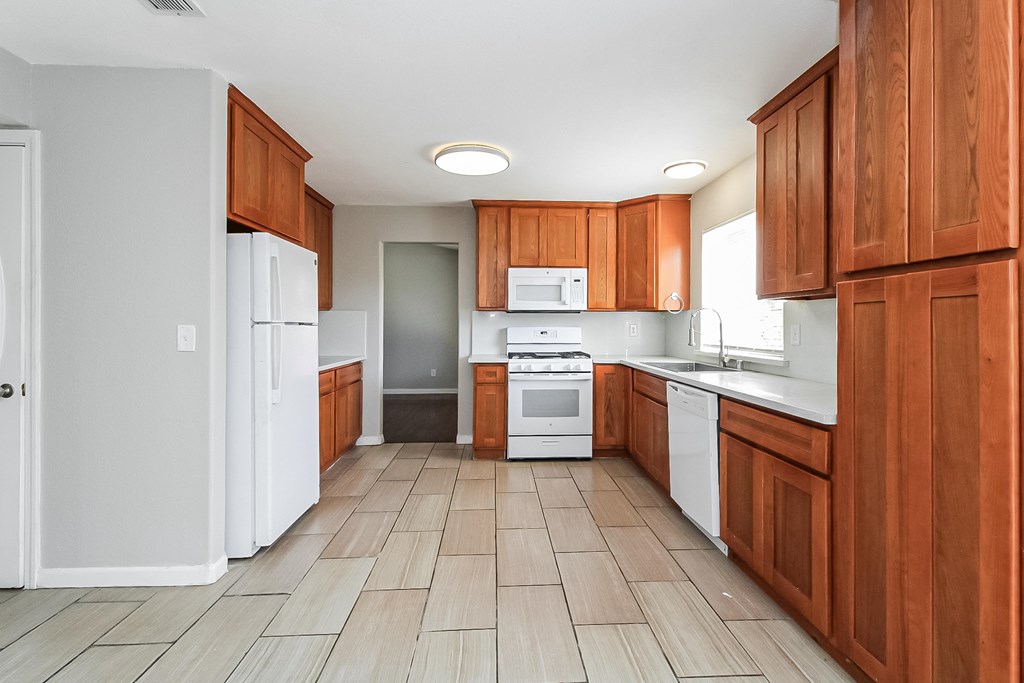 A kitchen with wooden cabinets and white appliances.