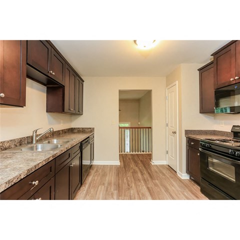 A kitchen with brown cabinets and a stove top oven.