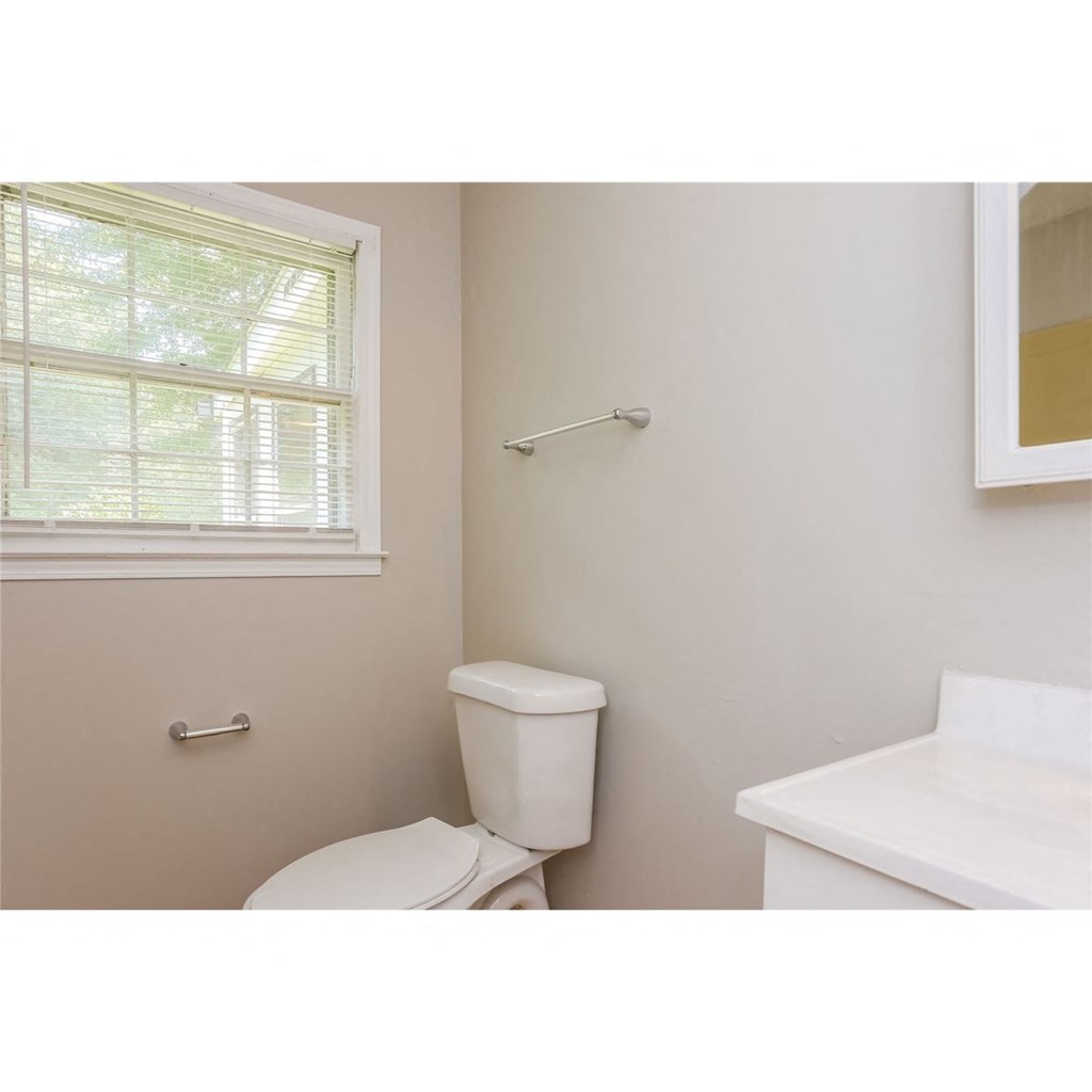 a bathroom with a toilet and a window