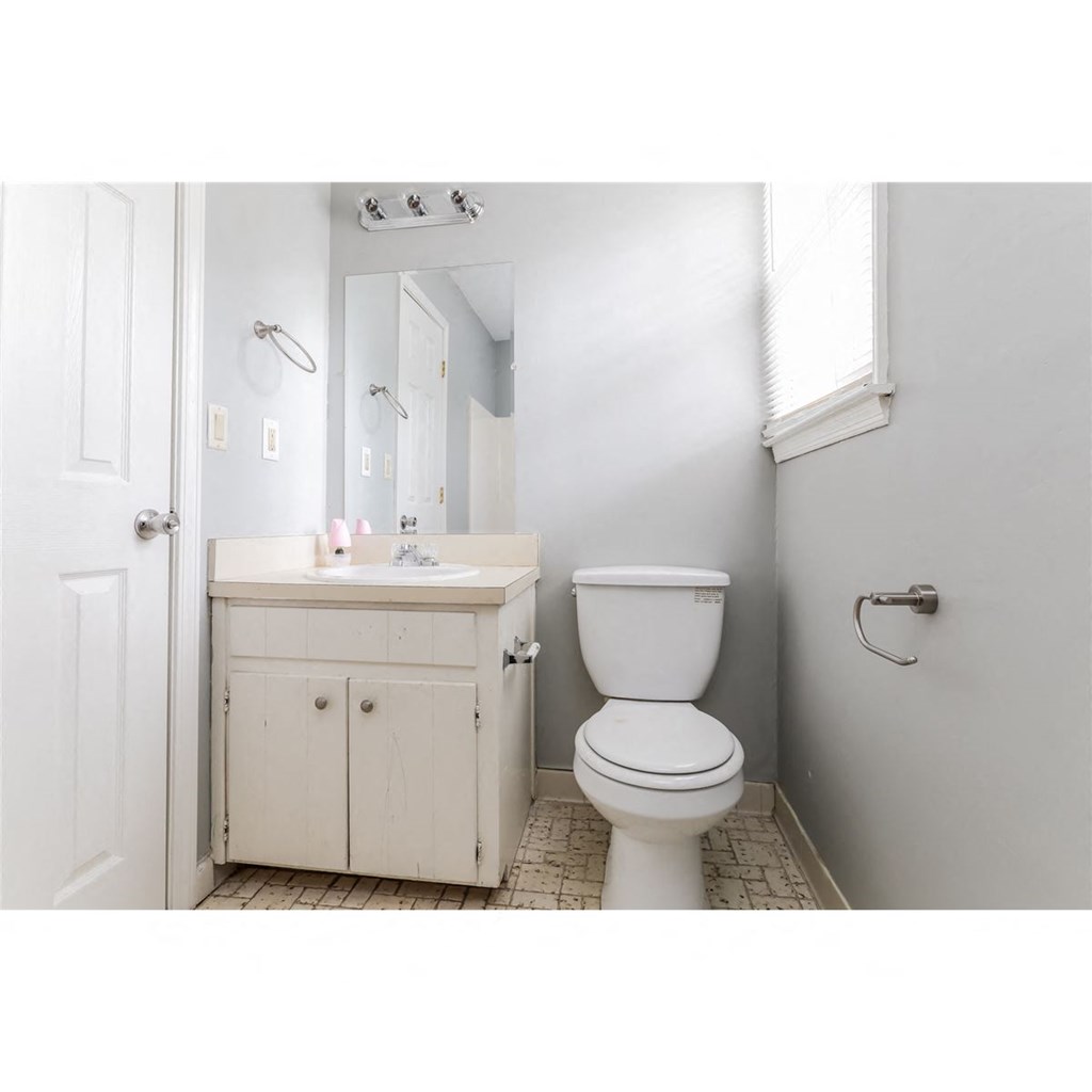 a white bathroom with a toilet and a sink
