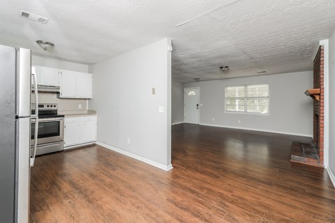 A kitchen with white cabinets and a refrigerator.