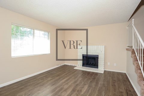 A living room with a fireplace and a large VRE picture on the wall.