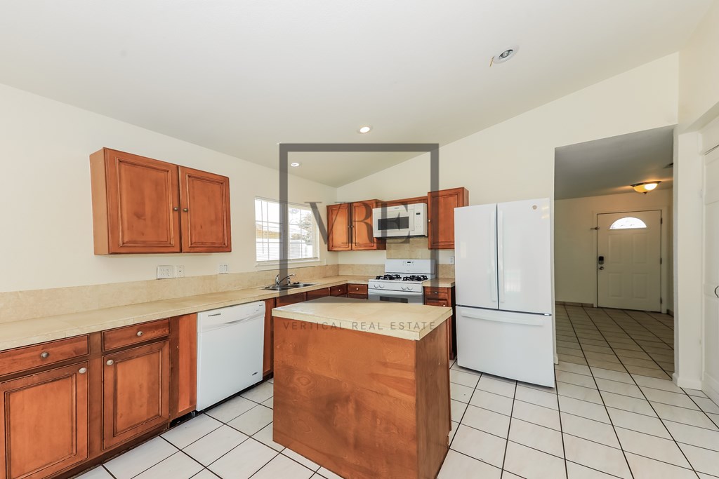 A kitchen with wooden cabinets and a white fridge.