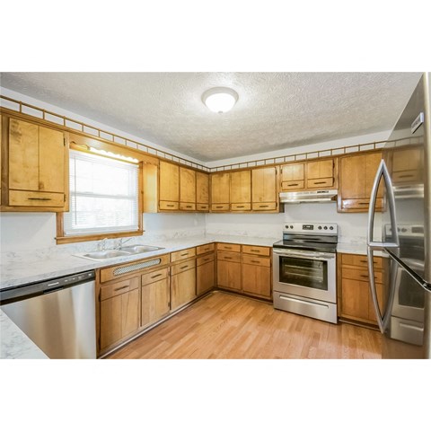 A kitchen with wooden cabinets and stainless steel appliances.