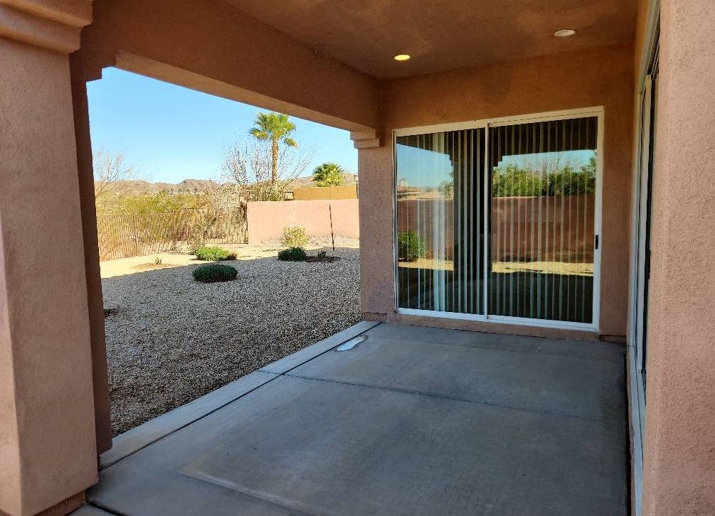 a patio outside of a home with a view of the yard